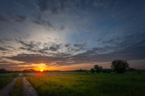 Sunset over meadow with road Stock-Fotos