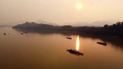 Sunset Over the Mekong River with Traditional Longboats and Mountain Landscape Stock Footage 342334818