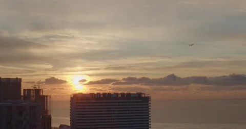 Sunset over modern city with flying plane in the sky view from balcony or Stock Footage 169902433