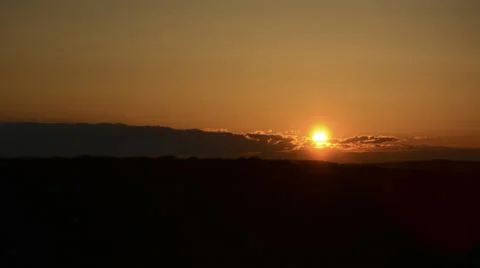 Sunset over mountain covered forest with rolling clouds time lapse wide Stock Footage 24693260