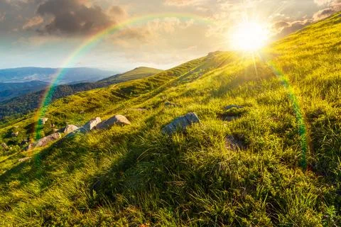 Sunset over mountain landscape with grass and rock on a slope 写真素材