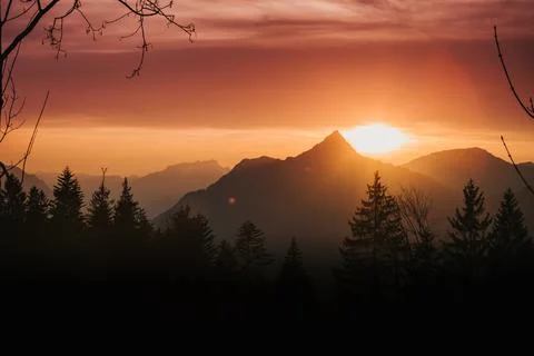 Sunset over a mountain peak in front of a lake Stock Photos