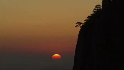 Sunset Over Mountain Peaks with Silhouetted Trees Video stock 327269020