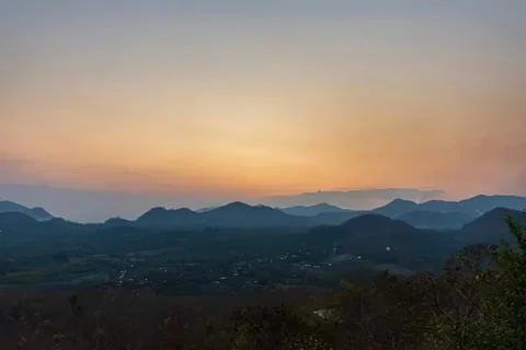 Sunset over mountain range with colorful sky and hills Stock Photos