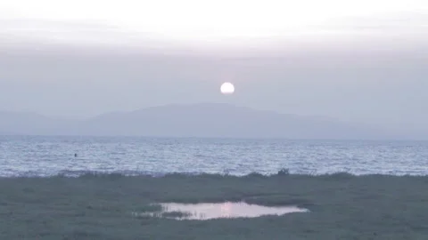 Sunset over mountain with shimmering bay water Stock Footage 252353341