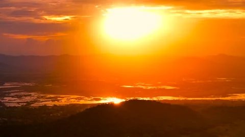 Sunset over mountain valley with sun reflecting in lakes and dramatic golden sky Stock Footage 320286943