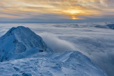 Sunset over the mountains and clouds in winter Stock Photos