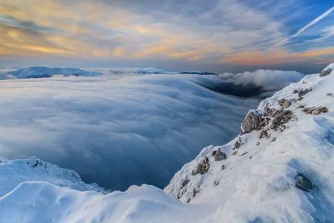 Sunset over the mountains and clouds in winter Stock Photos