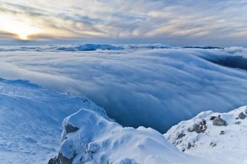 Sunset over the mountains and clouds in winter Stock Photos