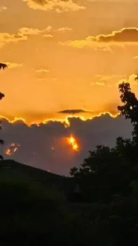 Sunset over mountains with clouds and trees silhouette Stock Photos
