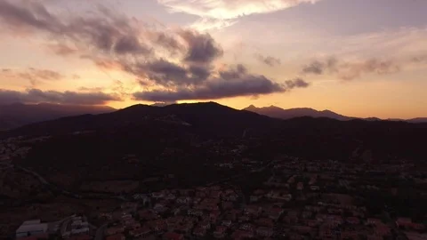 Sunset over the mountains with small village in front Stock Footage 82400948