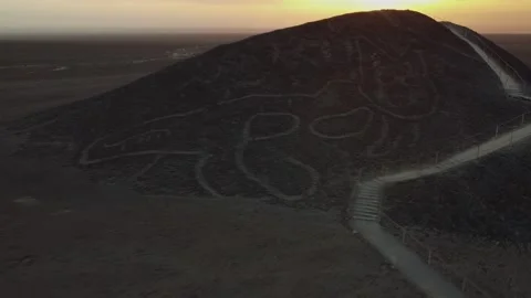 Sunset over the Nazca desert camera approaching hill with a Geoglyph called The  Stock Footage 252268375