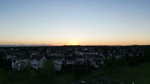 Sunset over the northwest of Calgary behind suburban detached houses Stock Footage 205579499
