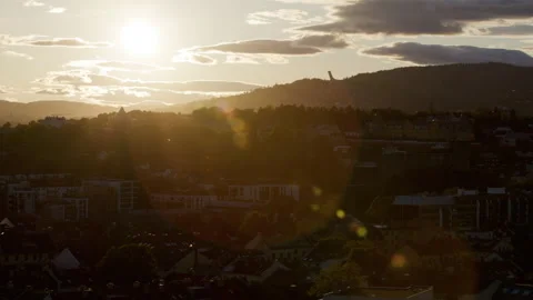 Sunset Over Norwegian City Rooftops with Distant Hills and Lens Flares Видео 337405099