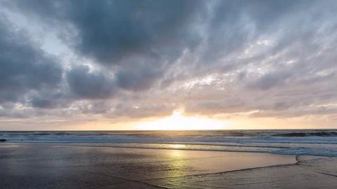Sunset over ocean beach with clouds Stock Photos