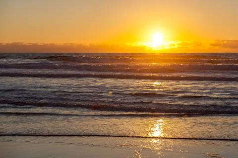 Sunset Over Ocean with Beach in the Foreground Stock Photos
