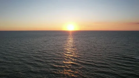 Sunset over the ocean with beautiful colors. Sun touches the water at the hor Stock Footage 217389983