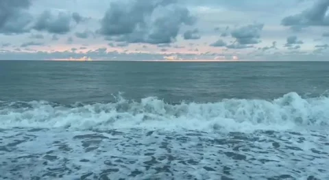 Sunset over the ocean with clouds and colors at a beach location in the eveni Vidéo 340649725