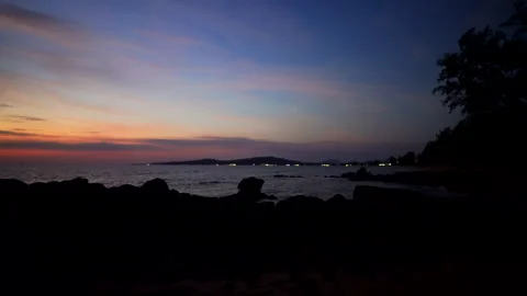 Sunset over ocean with clouds and ripples at shoreline during evening hours. Video stock 344279290
