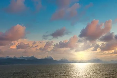 Sunset over ocean with colorful clouds and calm water Stock Photos