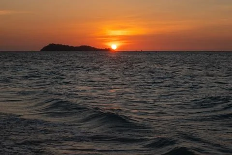 Sunset Over the Ocean with Distant Island Fotos Stock