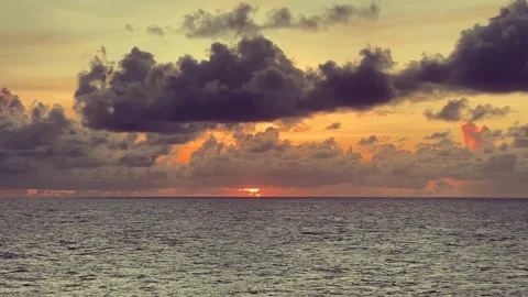 Sunset over ocean with dramatic clouds casting shadows on the water Stock Footage 338280459
