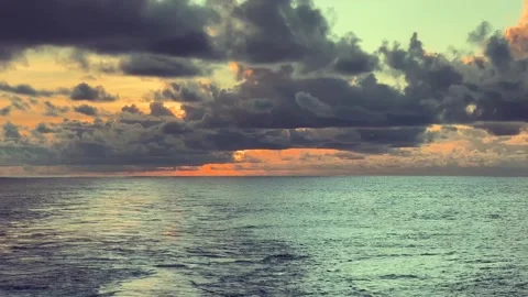 Sunset over the ocean with dramatic clouds and colorful sky reflected on th.. Stock Footage 338280494