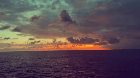 Sunset Over Ocean with Dramatic Clouds and Vibrant Hues Stock Footage 338281703