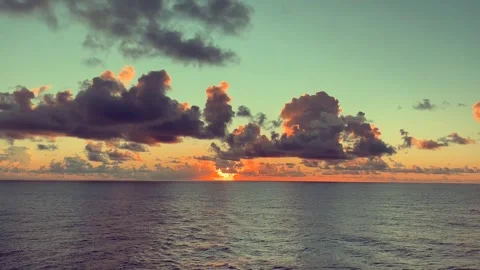 Sunset over the ocean with dramatic clouds and calm water Stock Footage 338282761
