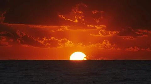 Sunset over ocean with dramatic clouds at dusk Stock Photos