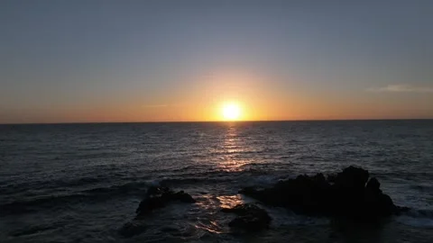 Sunset Over Ocean with Gentle Breeze, Clear Sky, and Rolling Waves Stock Footage 309945724