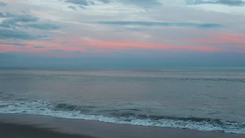 Sunset over the ocean with gentle waves and colorful sky at the beach. The sun Stock Footage 343797301