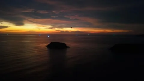 Sunset over ocean with islands and distant lights illuminating horizon Video stock 342332858