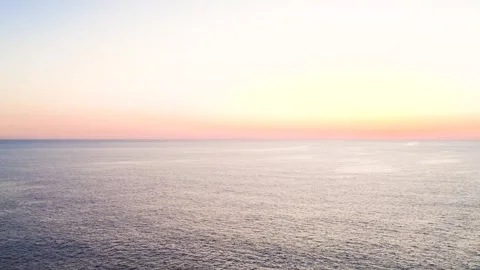Sunset Over the Ocean Reflecting Warm Colors Near the Coast at the End of the Stock Footage 334854490