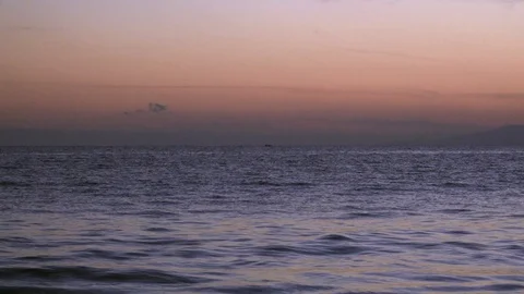 Sunset over the ocean with small boat on the horizon, slow motion Video stock 103765885