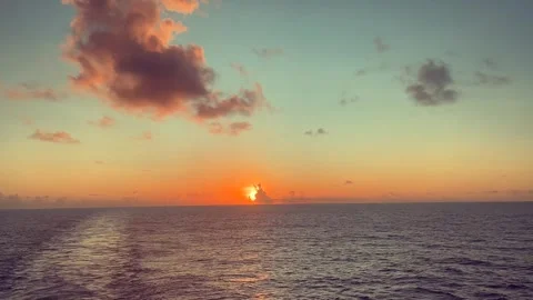 Sunset over the ocean with soft clouds in the sky creating a warm and peace.. Stock Footage 338282037