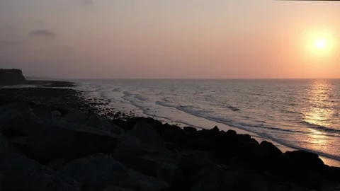 Sunset over the ocean with soft waves at Reculver Stock Footage 245994748
