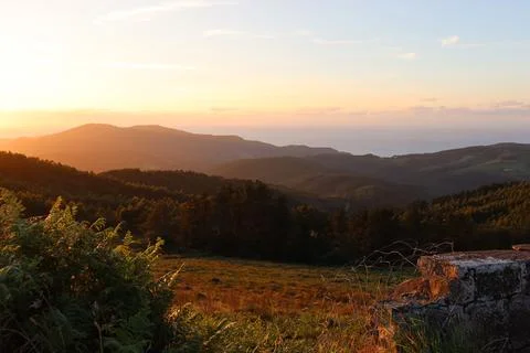 Sunset Over Ocean Through Forested Hills from Sollube, Basque Country, Spain Foto stock