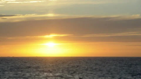 Sunset over the ocean in timelapse. The Sun glows strongly, then disappears. Stock Footage 67647563