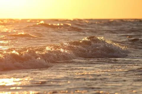 Sunset over ocean waves with warm golden colors Stock Photos