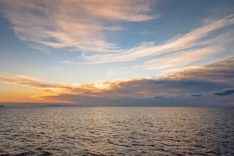 Sunset over ocean in wide angle view with reflection on water Stock Photos