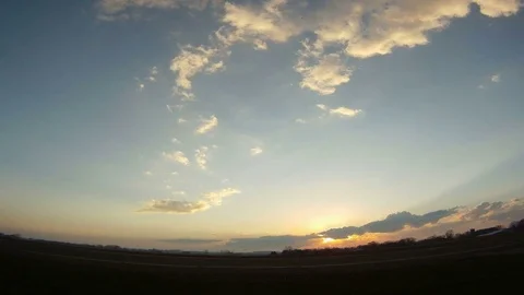 Sunset over a open field with light clouds passing overhead. Wide panorama view. Video stock 105318584