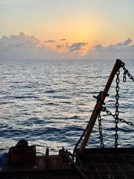 Sunset Over Open Ocean Viewed From Cargo Ship Deck With Safety Railing Silhouett Stock Photos