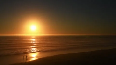 Sunset over the Pacific Ocean with silhouetted people on the shore Stock Footage 278193334