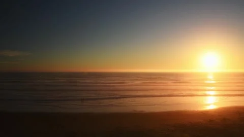 Sunset over the Pacific Ocean with silhouetted people playing in the water Stock Footage 278193336