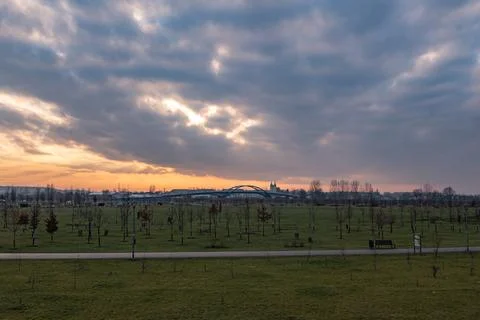 Sunset over park overlooking arched bridge Foto stock