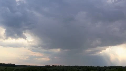 Sunset over a peaceful forest with clouds clearing to reveal sunbeams. Time Stock Footage 276266445