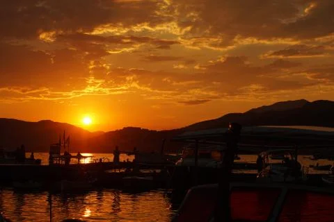 Sunset over a pier full of small fishing boats Foto stock