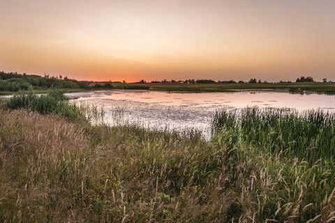 Sunset over pond next to path between Polczyn Zdroj town and Zlocieniec, Poland Stock Photos