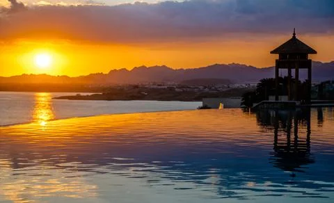 Sunset over the pool overlooking the sea Foto stock